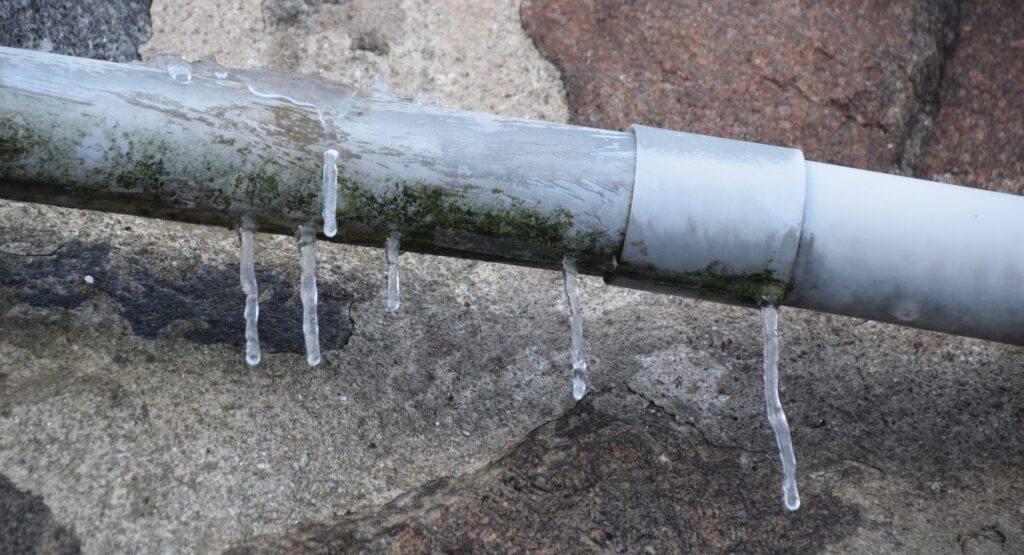 Frozen pipe with icicles forming