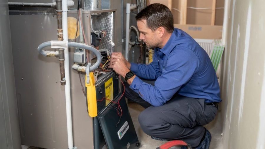 HVAC tech performing furnace repair.
